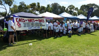 Relay for Life team holding a banner reading Cats in Hats with Bats